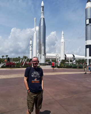 Professor Bill Chaplin in front of several rockets at Cape Canaveral