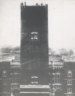 black and white photo of Old Joe clock tower being constructed with men on top working
