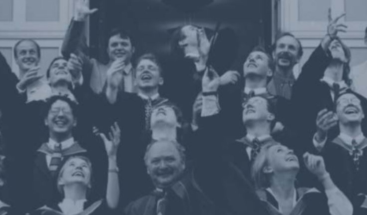 A group of happy students at graduation, throwing their caps in the air