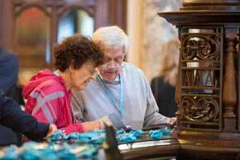 An elderly woman and man looking at name badges