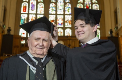 Stephen Goodall and grandson Stephen Denbigh in the Great Hall wearing graduation caps and gowns