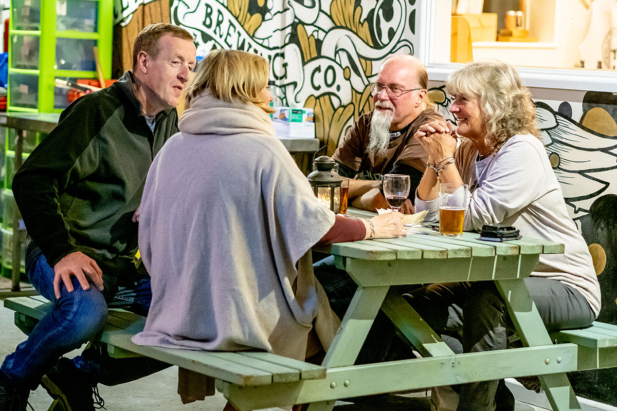 Group of four people sitting at table indoors