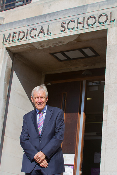 Dr Ian Smith standing in front of Birmingham Medical School