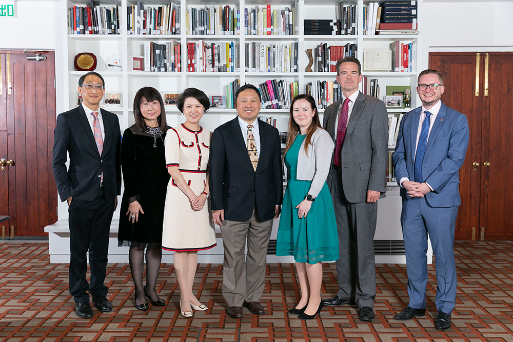 A group of businessmen and women smile to camera