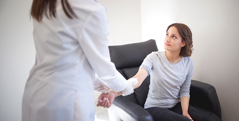 Young woman receiving blood test from nurse