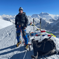 Oscar stands in the snow at the top of Mera Peak in the Himalayas.