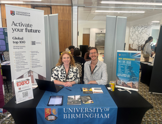 two people sit at a table that says University of Birmingham