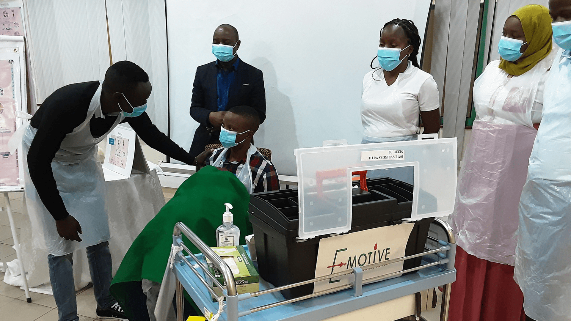 a group of healthcare professionals in Tanzania investigate the contents of a E-MOTIVE box, trialling its use.