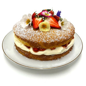 Victoria sponge cake decorated with flowers and strawberries