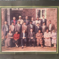 Class of 1991 - a group of around 15 adults pose in rows for a formal photo.