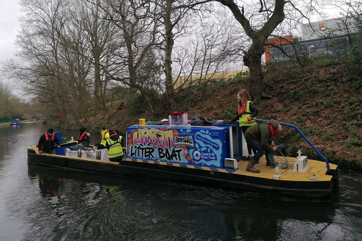 Student volunteers clear waste from canal